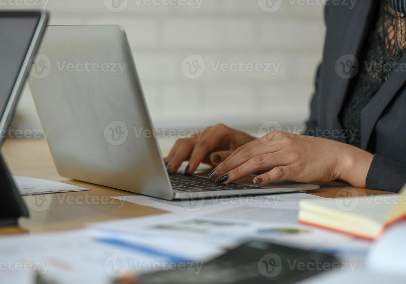 le dipendenti di sesso femminile stanno utilizzando un laptop sulla scrivania in ufficio. foto