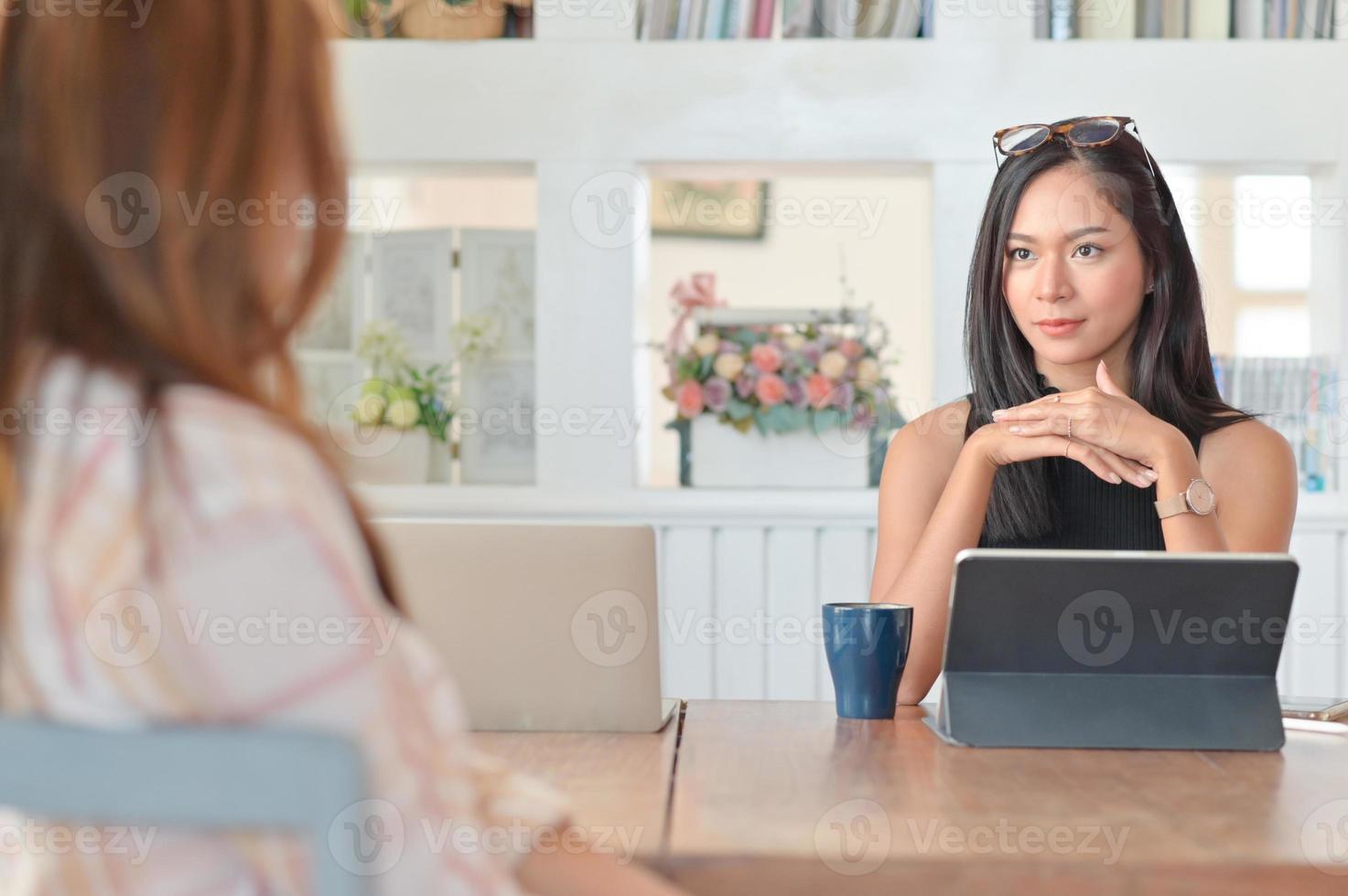 belle donne d'affari sedute e ascoltano il personale che riassume i risultati in un comodo ufficio. foto