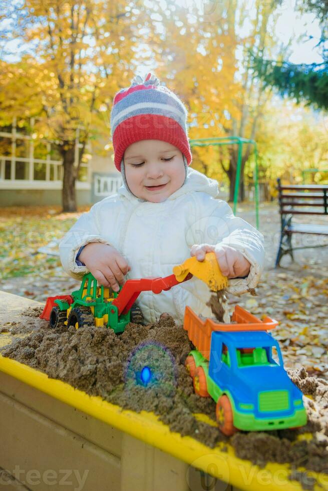 il bambino giochi macchine su il terreno di gioco foto