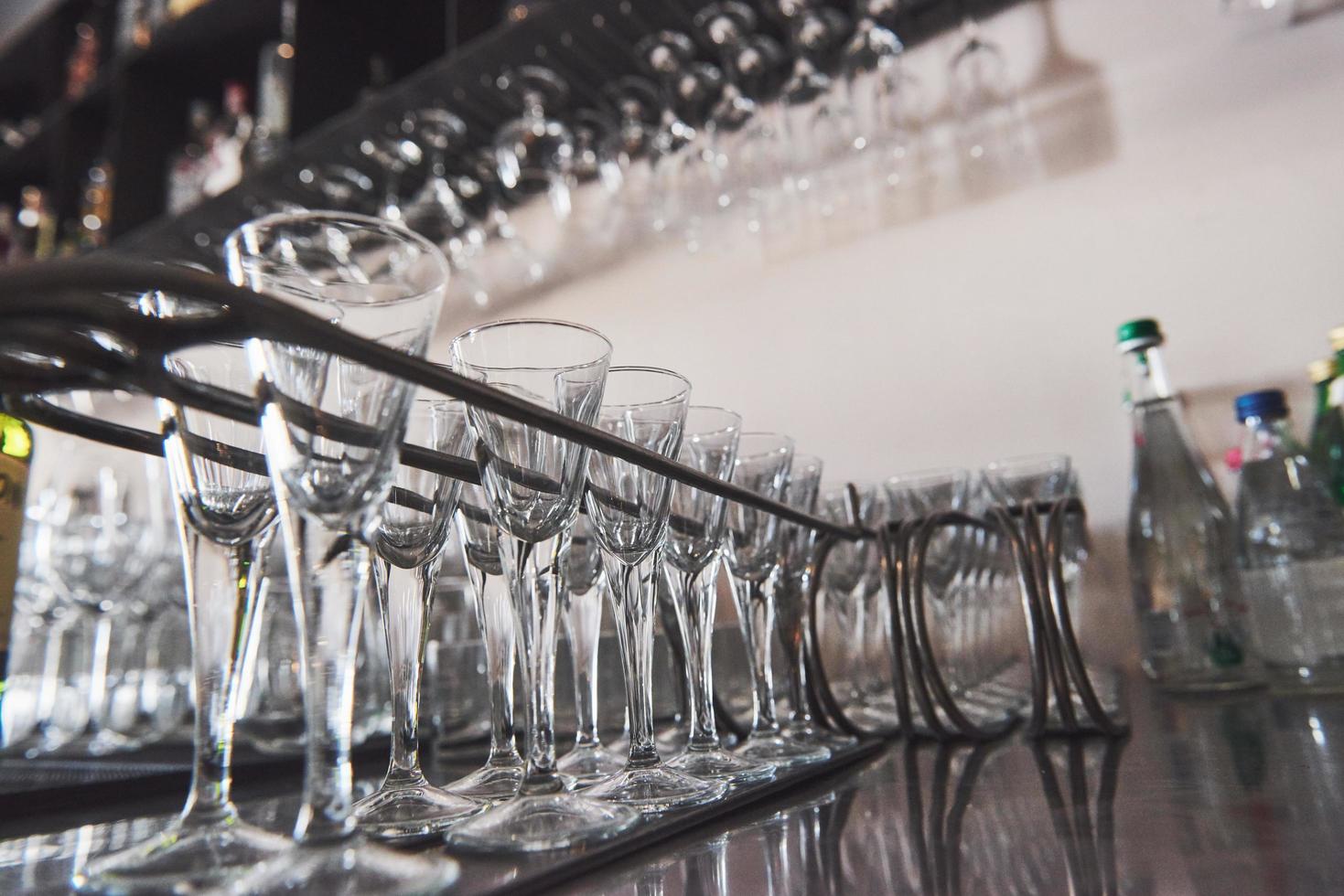 bicchieri vuoti per vino sopra un portabottiglie in tono vintage foto