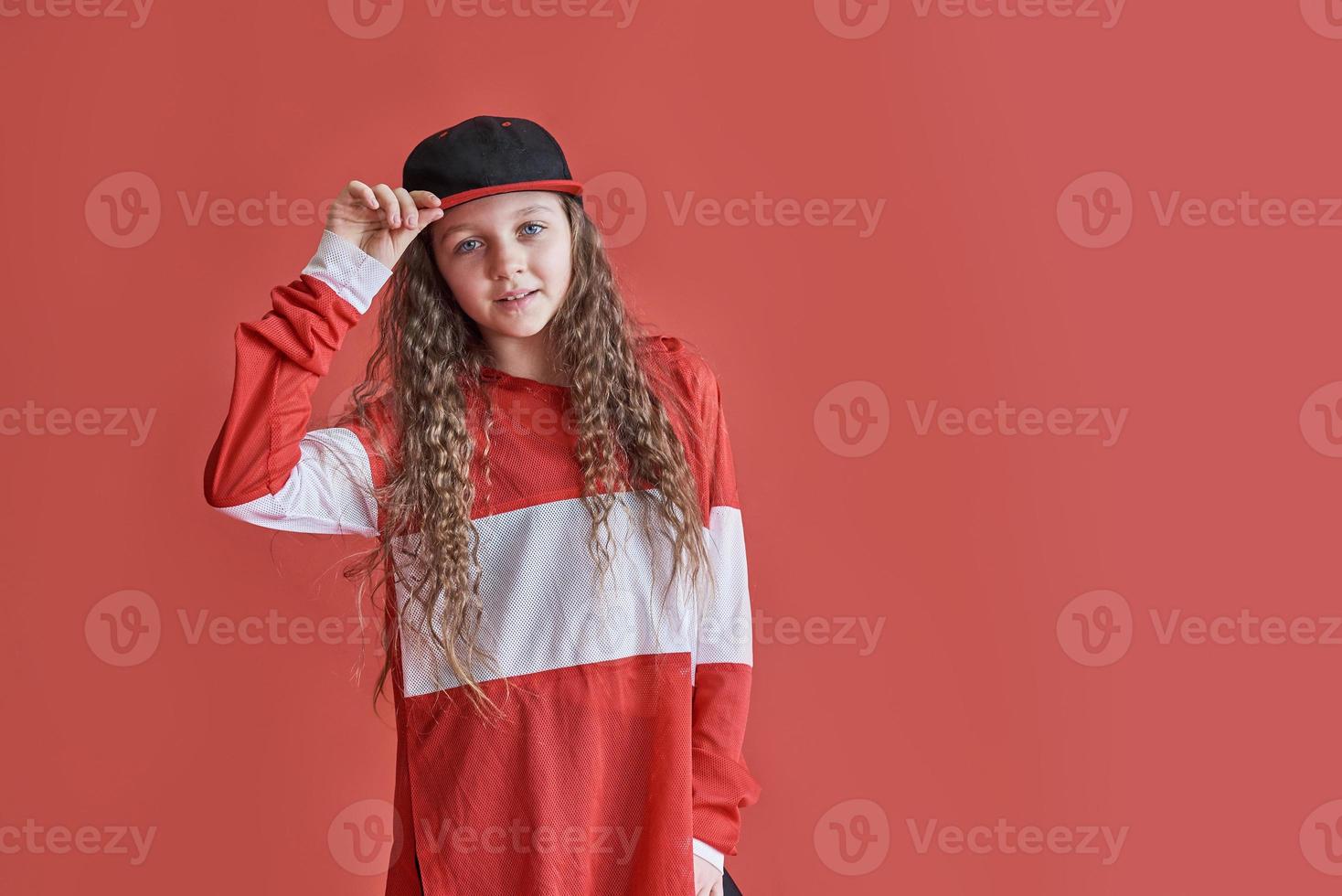giovane donna urbana che balla su sfondo rosso, moderna e sottile ragazza adolescente in stile hip-hop foto