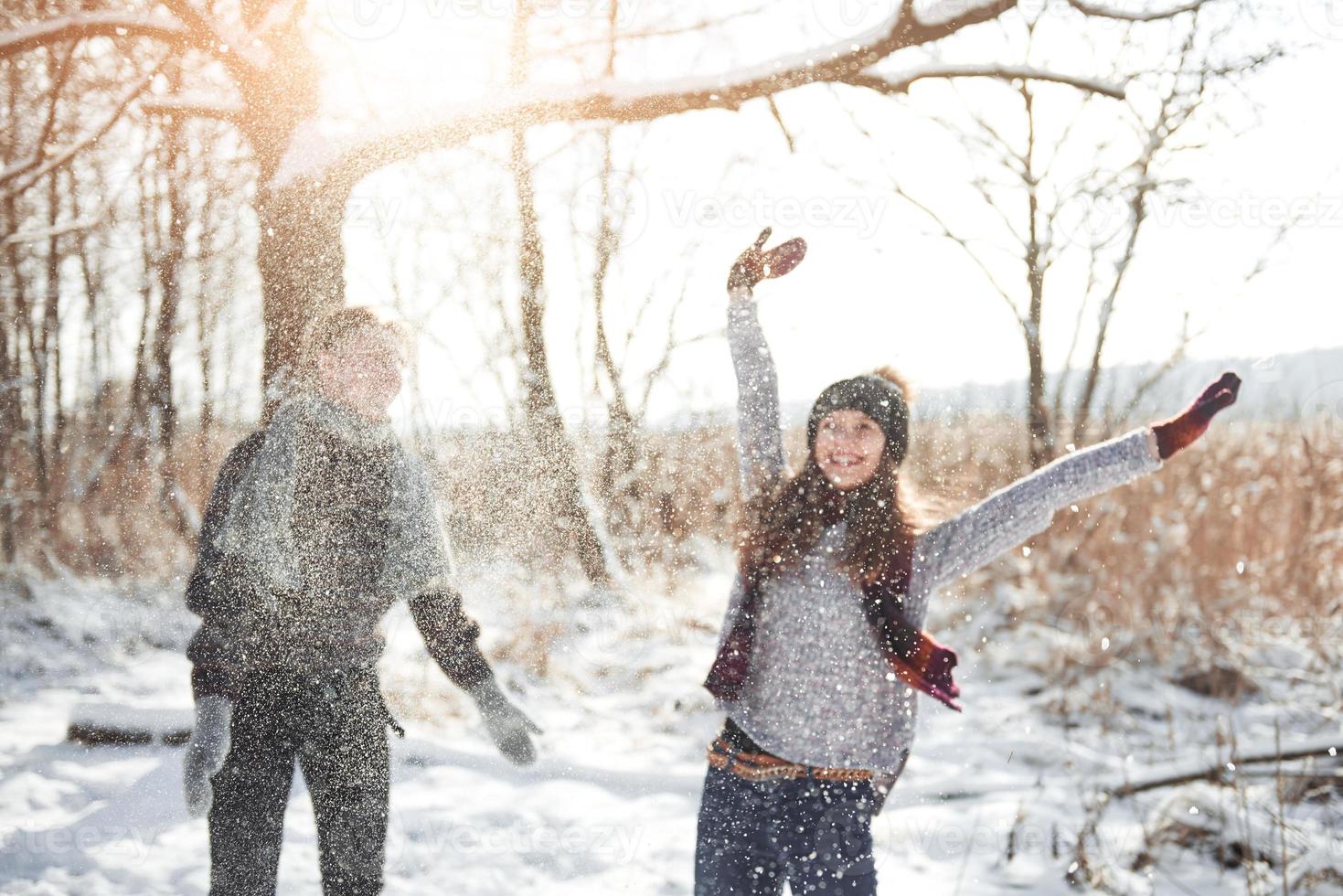 la coppia si diverte e ride. bacio. giovane coppia hipster che si abbracciano a winter park. storia d'amore invernale, una bella coppia giovane ed elegante. concetto di moda invernale con fidanzato e fidanzata foto