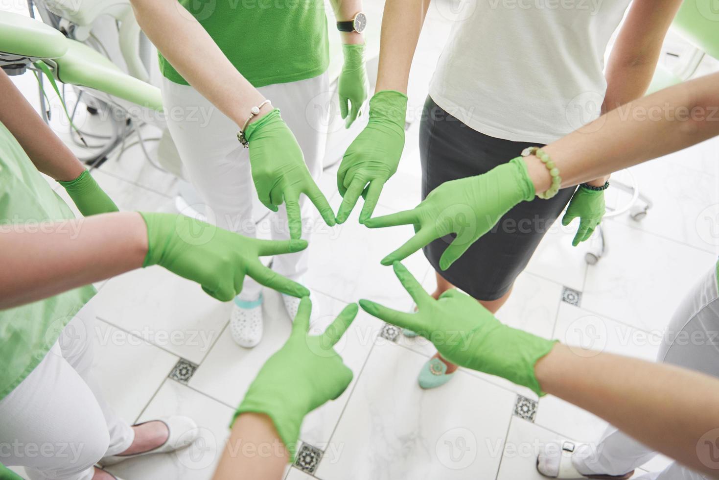 medici e infermieri in un team medico che si accatastano le mani foto