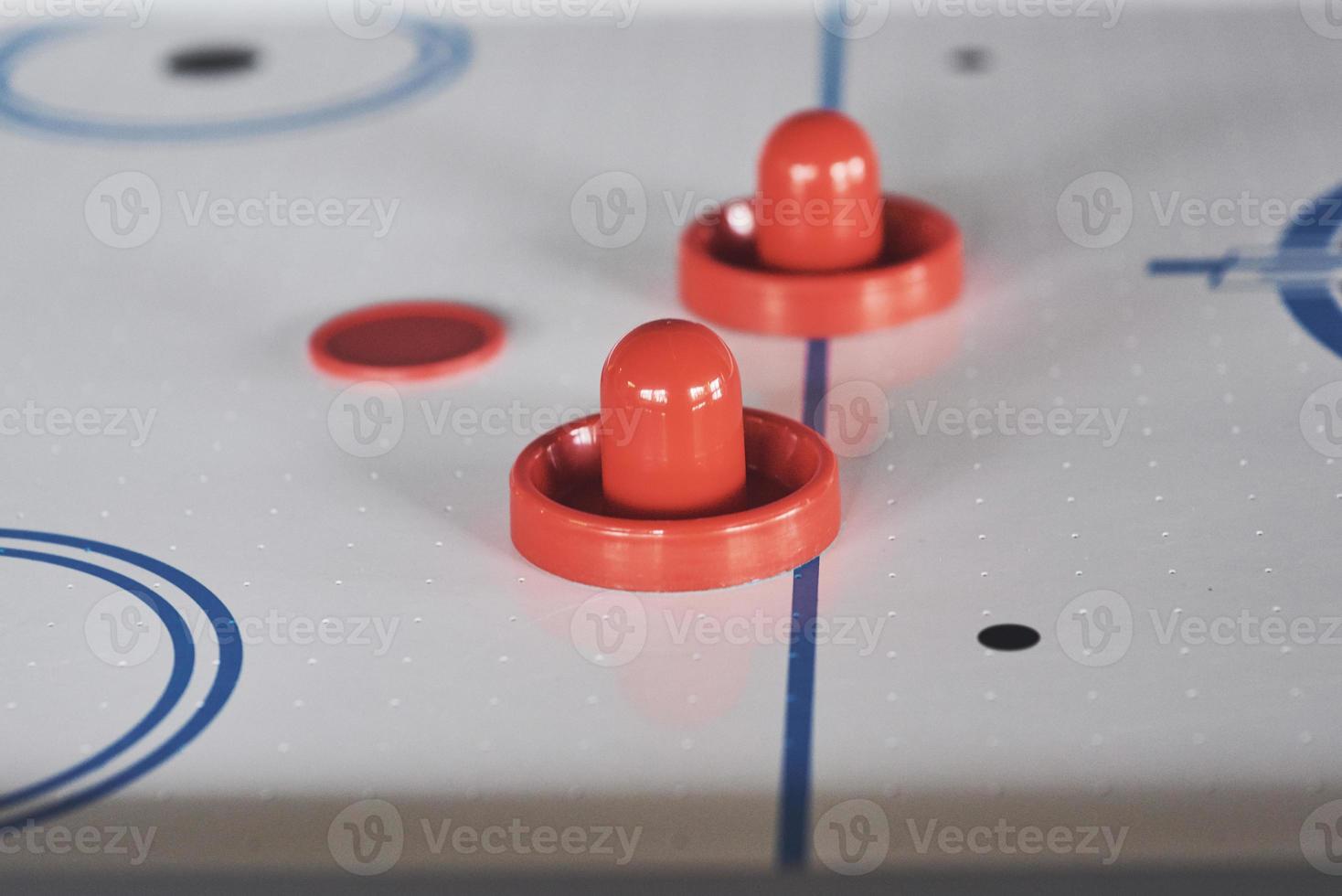 tavolo da air hockey con illuminazione della finestra e mazza da hockey giocattolo rossa foto