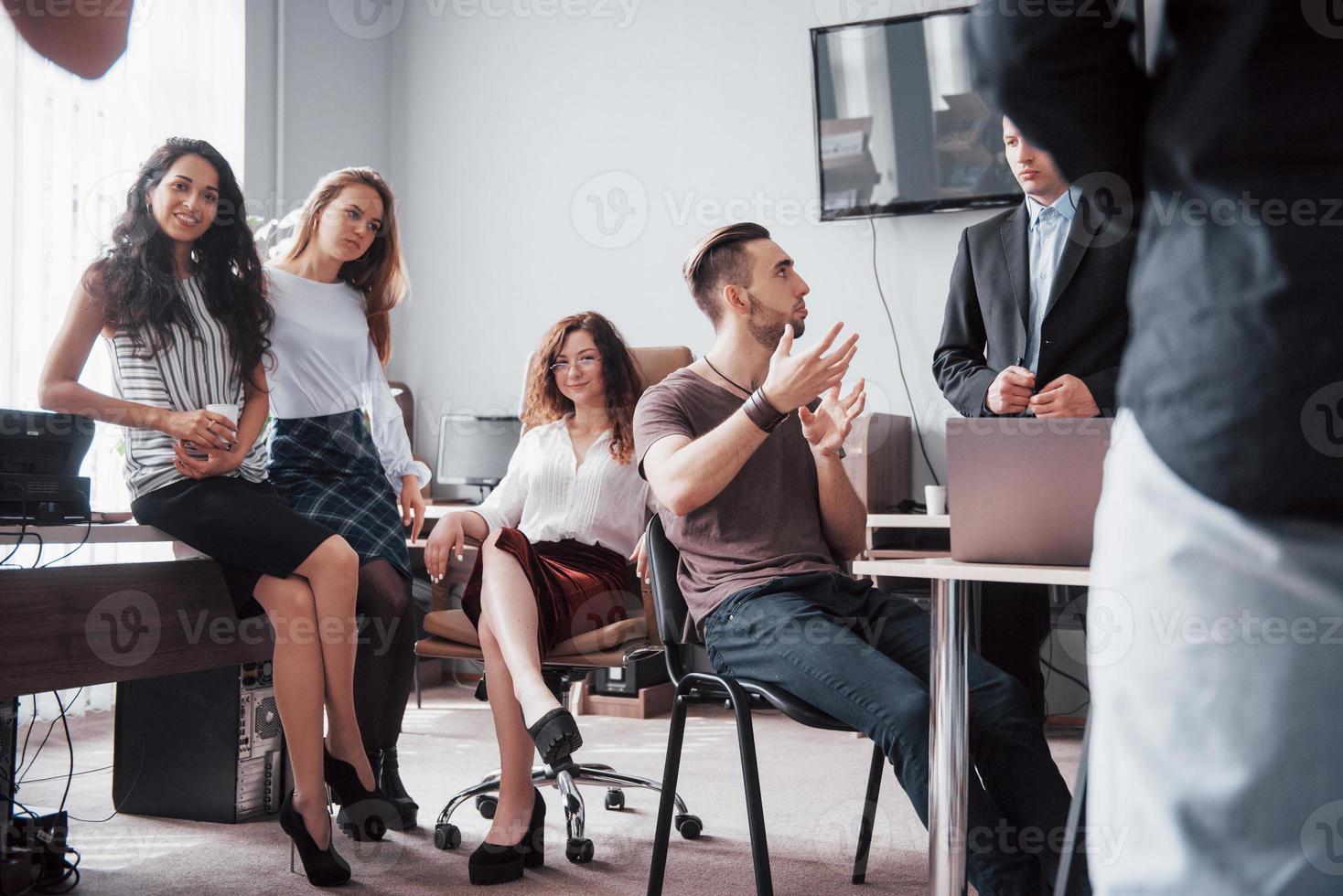 giovani colleghi felici che discutono in riunione presso l'ufficio creativo foto