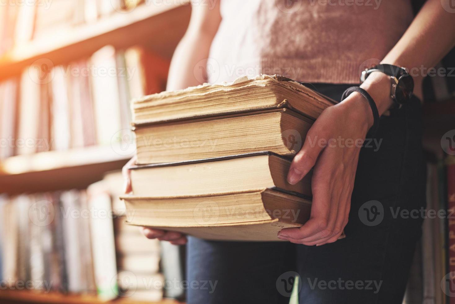 una giovane studentessa in cerca di letteratura vicino agli scaffali della vecchia biblioteca foto