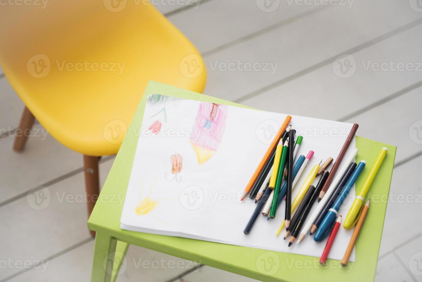 una cornice con un bambino che disegna e matite colorate foto