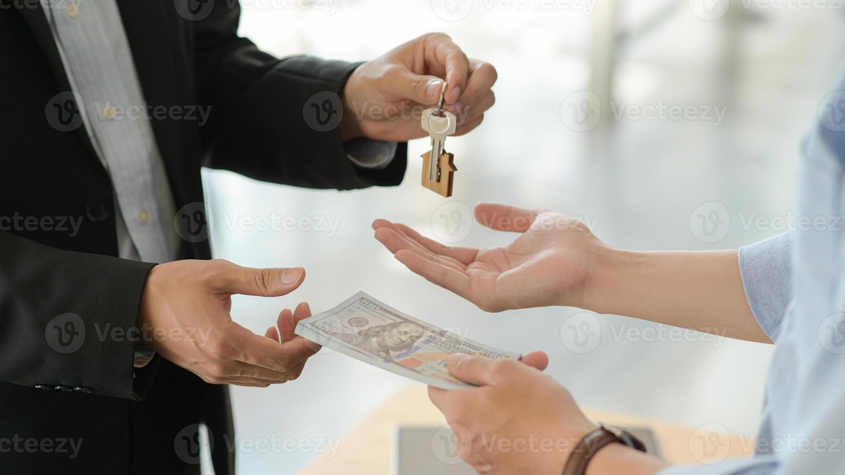 clienti e proprietari si scambiano denaro e chiavi dopo aver accettato di acquistare una casa. foto