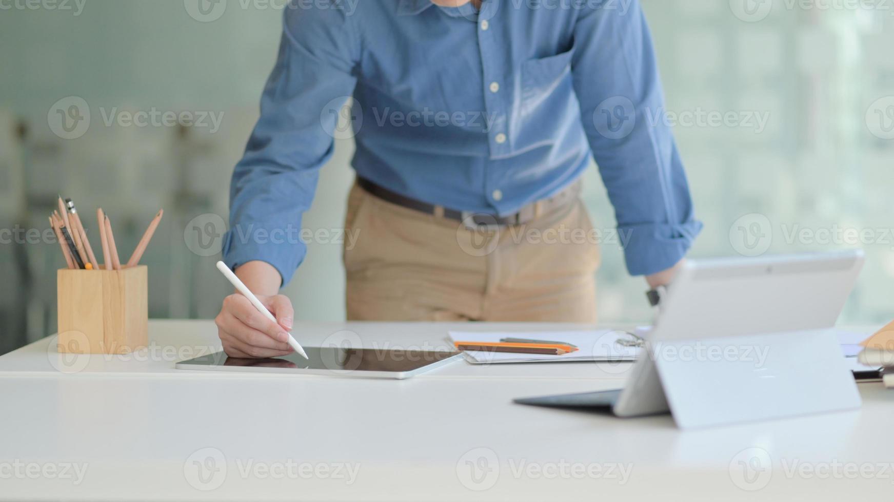 un designer professionista sta lavorando su un moderno tablet per disegnare il suo progetto futuro in un comodo ufficio. foto