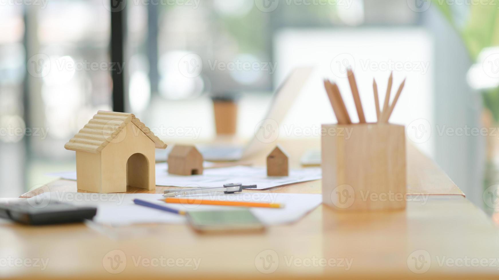 strumenti di disegno della casa mockup e casa modello in legno sulla scrivania in ufficio. foto