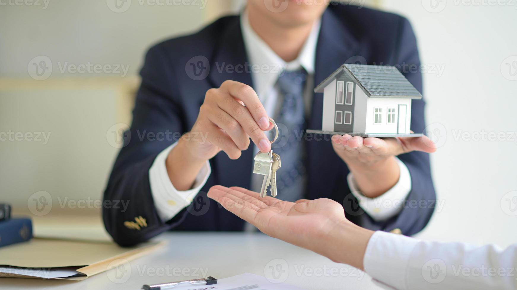 il broker di vendita della casa tiene le chiavi e la casa modello viene data ai clienti, concetto immobiliare. foto