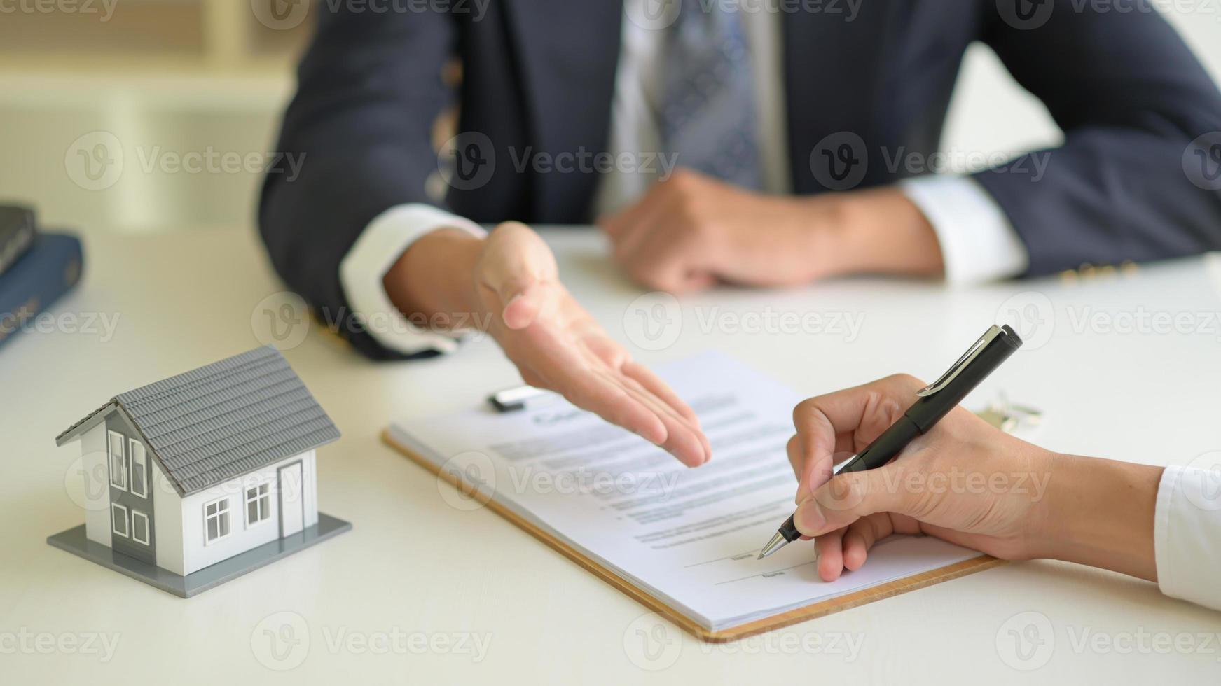 firmare un contratto di acquisto casa tra l'intermediario immobiliare e il cliente. foto