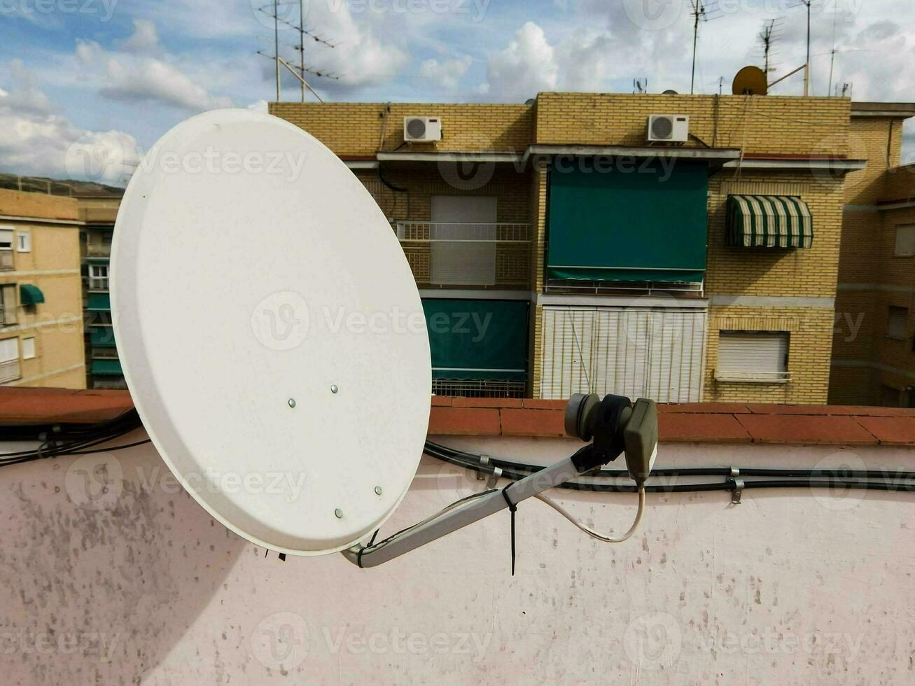 un' satellitare piatto su un' tetto di un' edificio foto