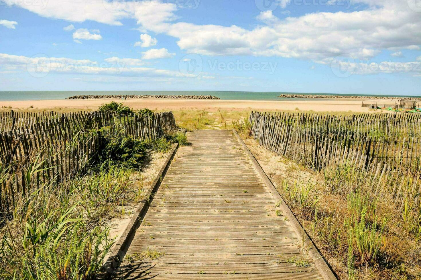 un' di legno passerella conduce per il spiaggia e il oceano foto