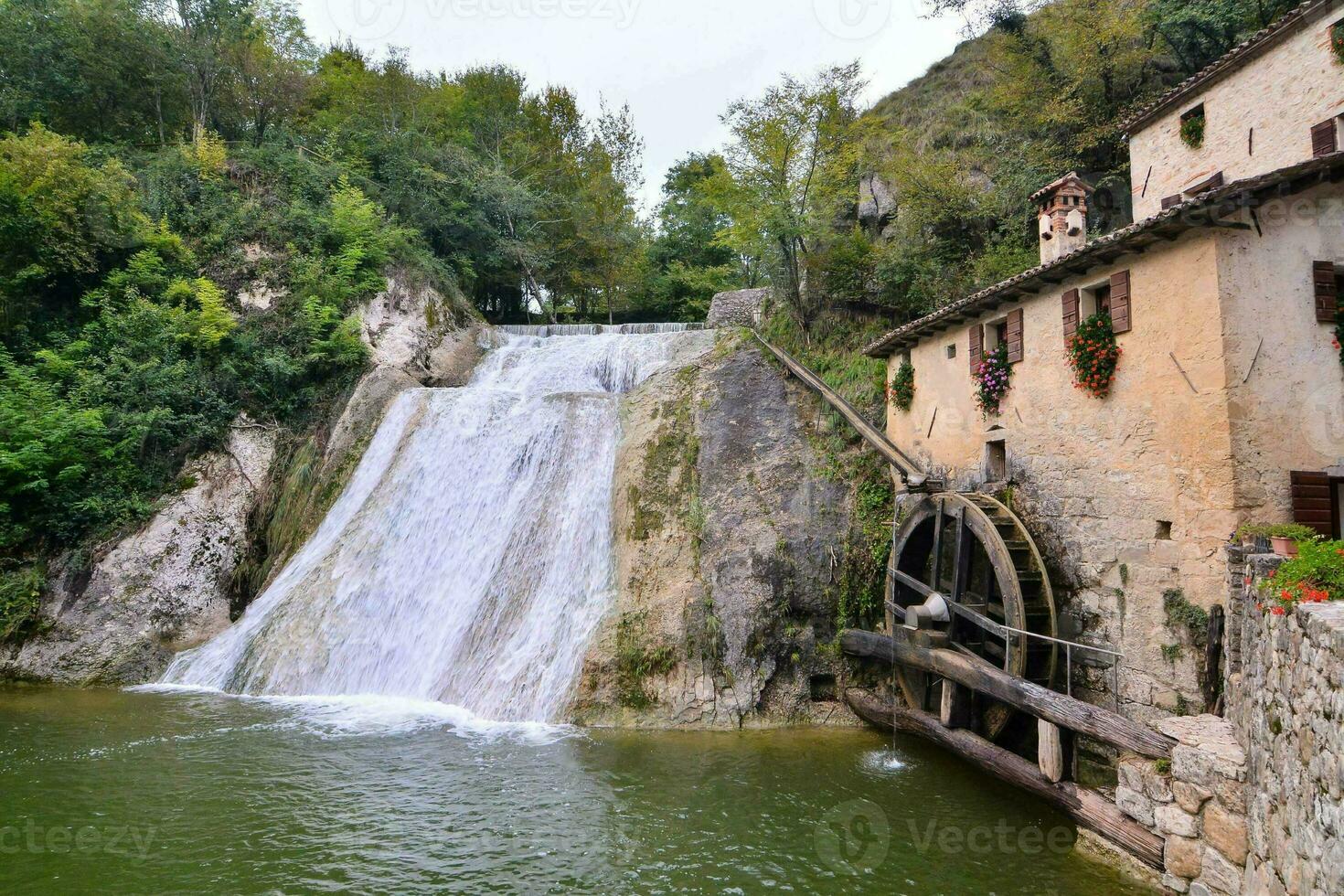 un' acqua ruota e un' cascata nel il mezzo di un' fiume foto