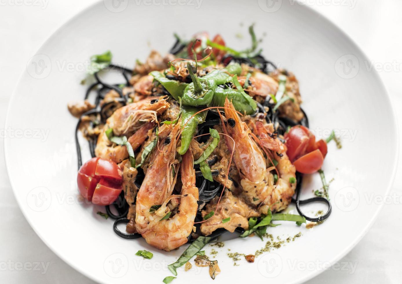 spaghetti al nero di seppia con gamberi e verdure miste foto