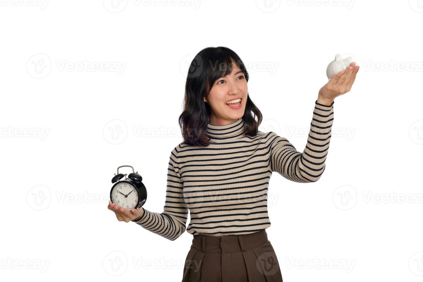 contento asiatico donna con maglione camicia Tenere allarme orologio e porcellino banca isolato su bianca sfondo foto
