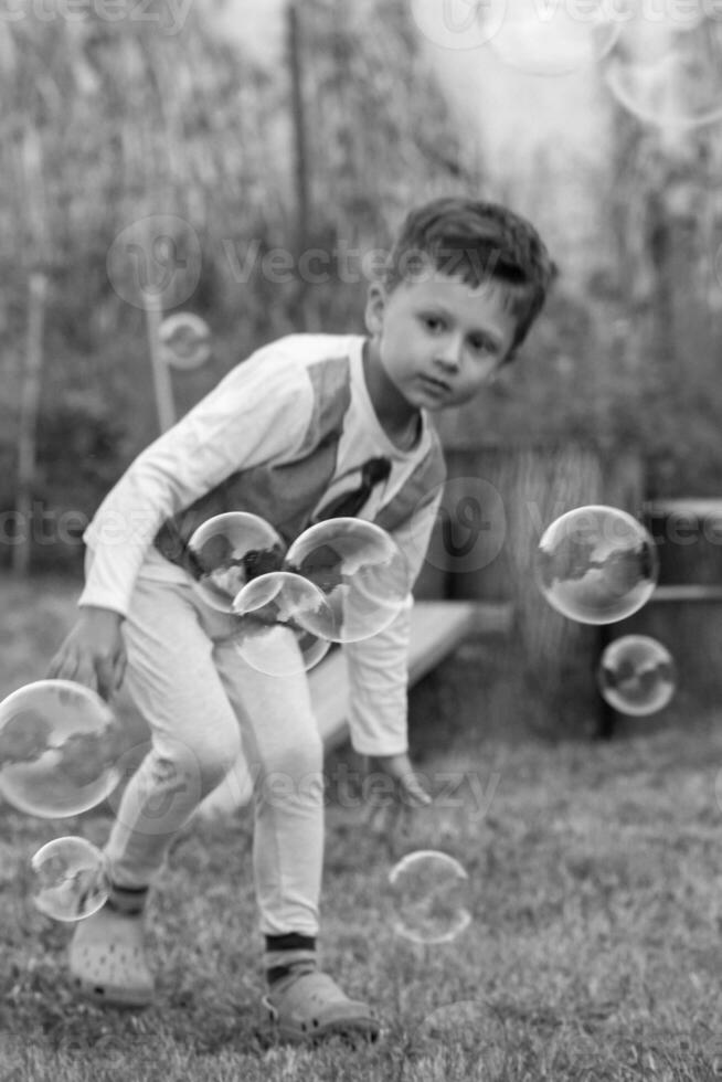 bellissimo bambino ragazzo con bambino sapone bolle in posa fotografo per freddo foto