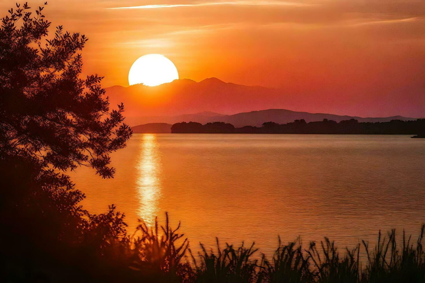 ai generato il sole imposta al di sopra di un' lago con alberi e montagne nel il sfondo foto