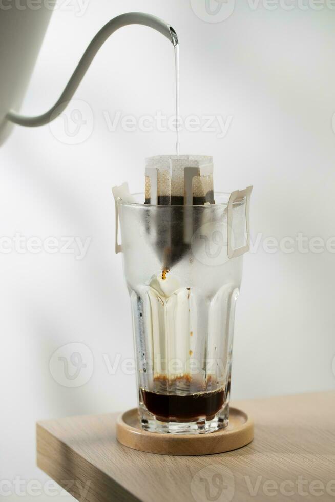il caldo acqua è versato al di sopra di il arrostito e terra caffè, nel un' filtro carta pronto per uso. foto