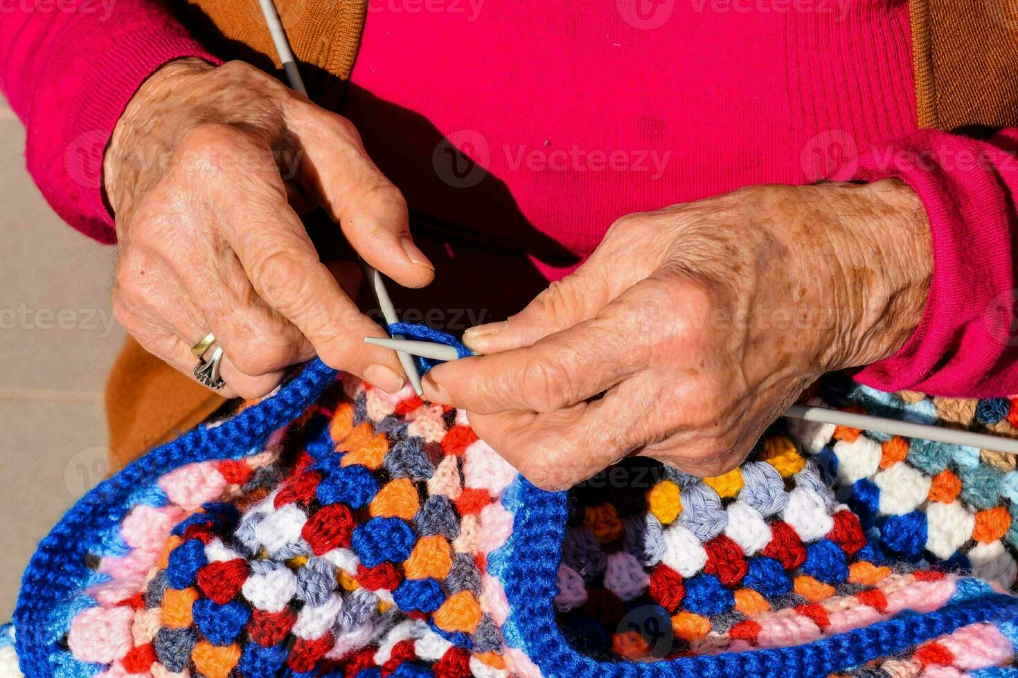 un più vecchio donna è maglieria un' colorato uncinetto coperta foto