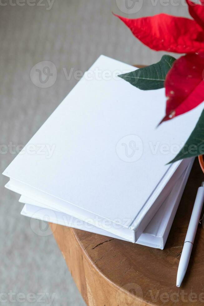 vuoto libri con penna e poinsettia pianta foto