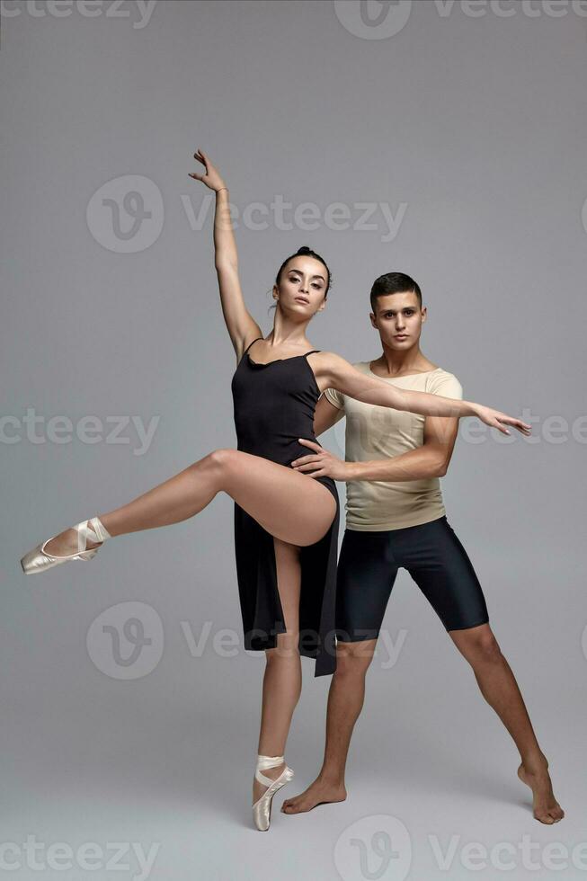 Due atletico moderno balletto ballerini siamo in posa contro un' grigio studio sfondo. foto