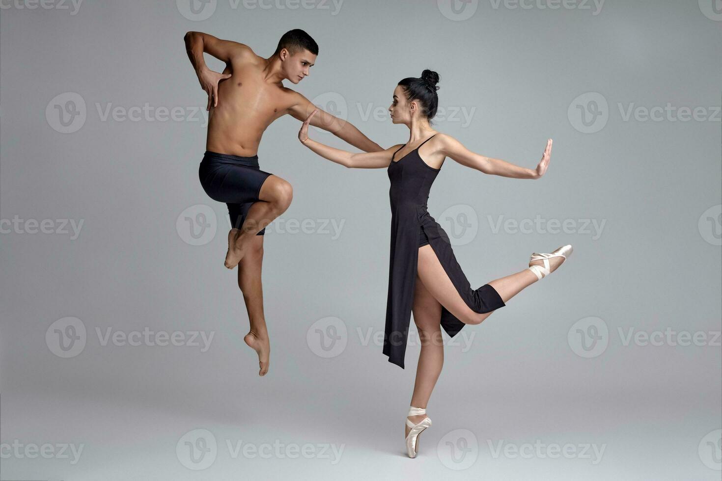 Due atletico moderno balletto ballerini siamo in posa contro un' grigio studio sfondo. foto