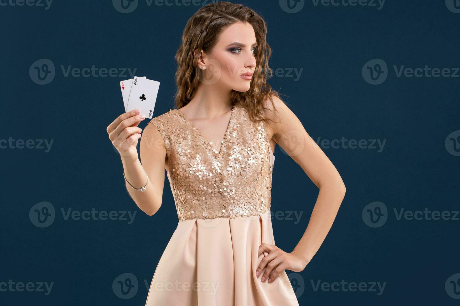 giovane bellissimo donna Tenere il vincente combinazione di poker carte su buio blu sfondo. Due assi foto