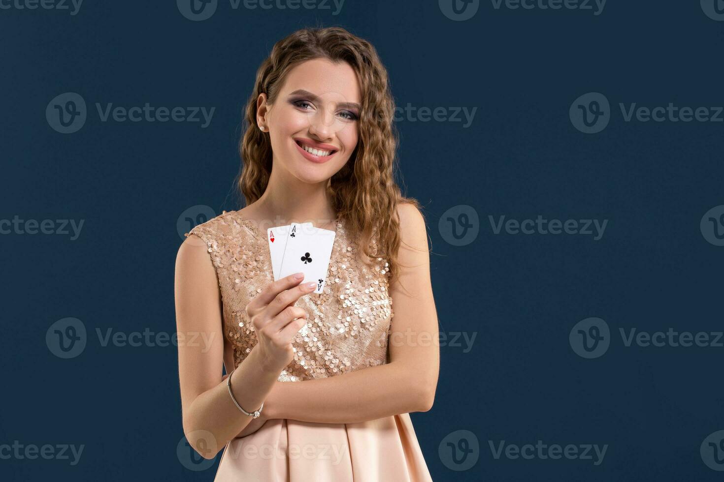 giovane bellissimo donna Tenere il vincente combinazione di poker carte su buio blu sfondo. Due assi foto