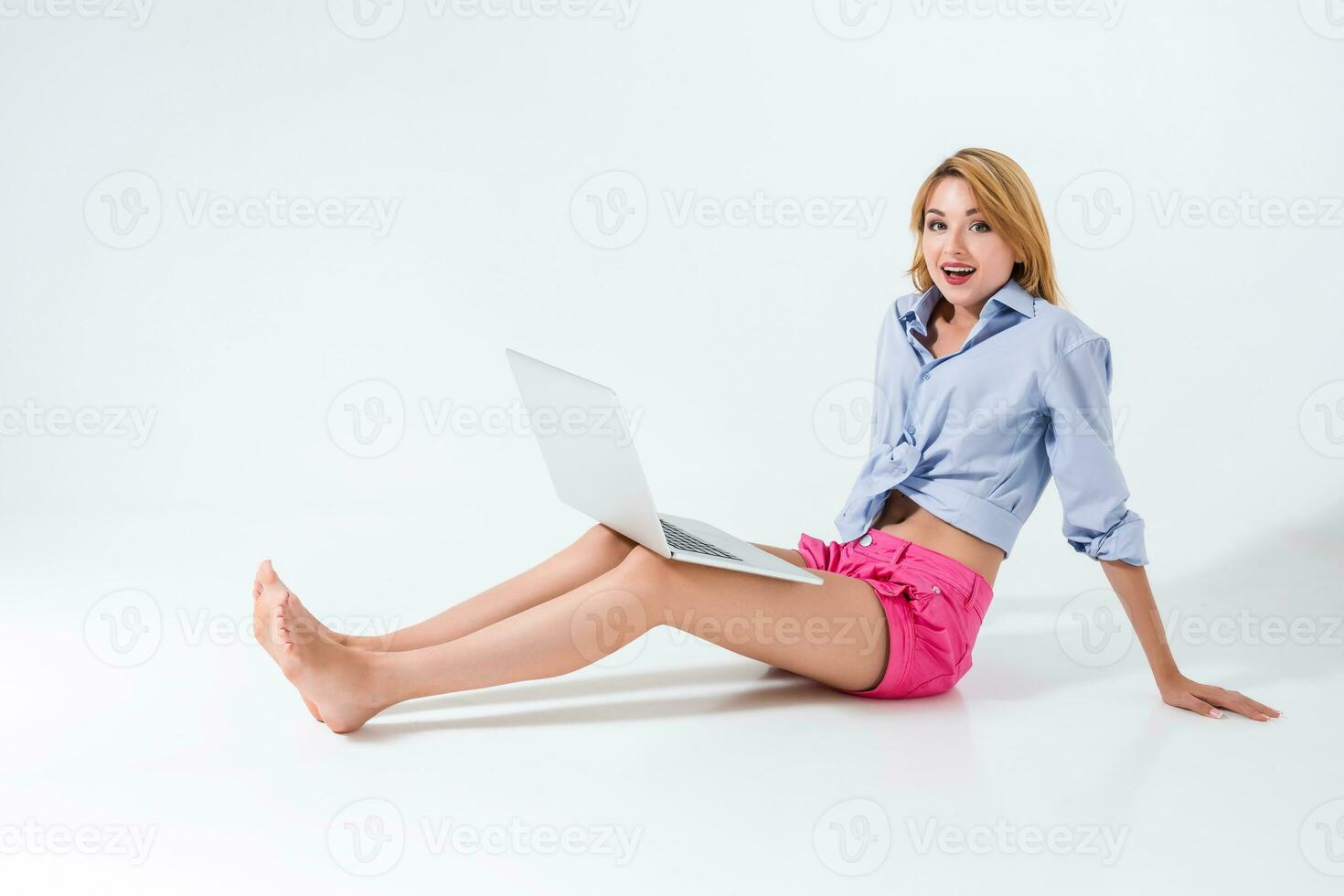 giovane donna seduta su il pavimento e utilizzando il computer portatile foto