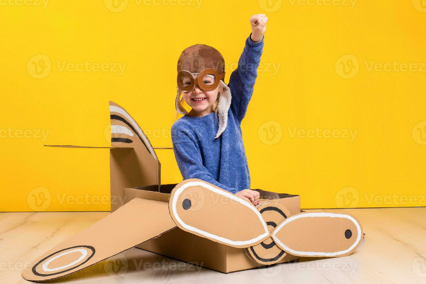 poco sognatore ragazza giocando con un' cartone aereo. infanzia. fantasia, immaginazione. foto