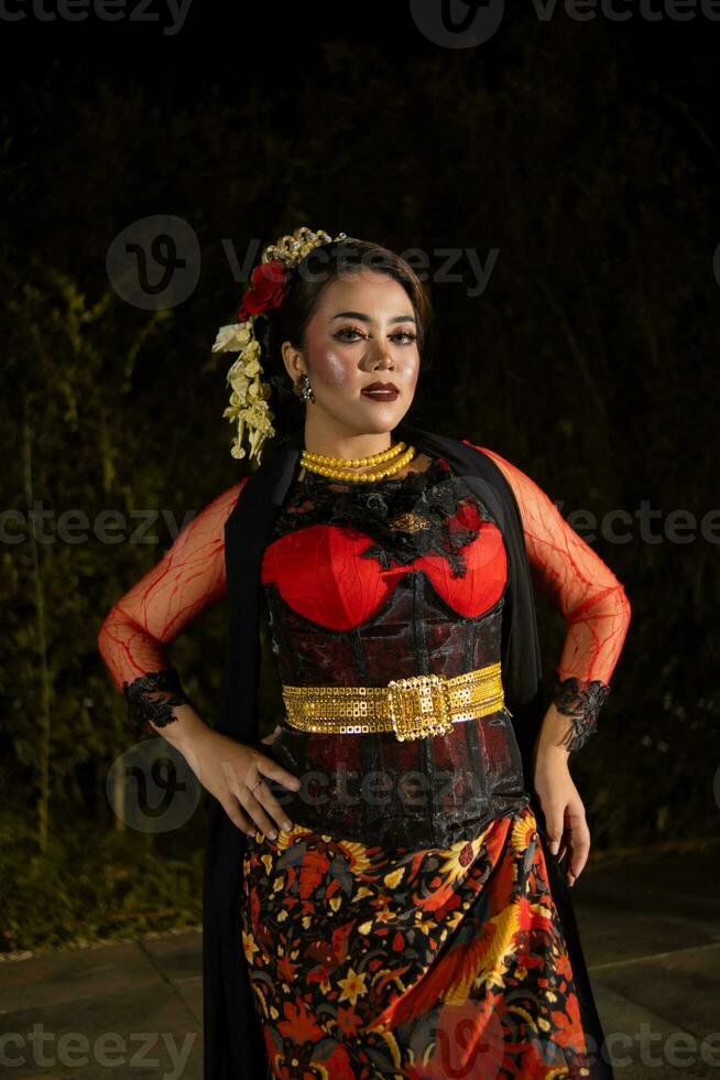 un indonesiano ballerino nel un' oro e rosso costume sta molto con grazia foto