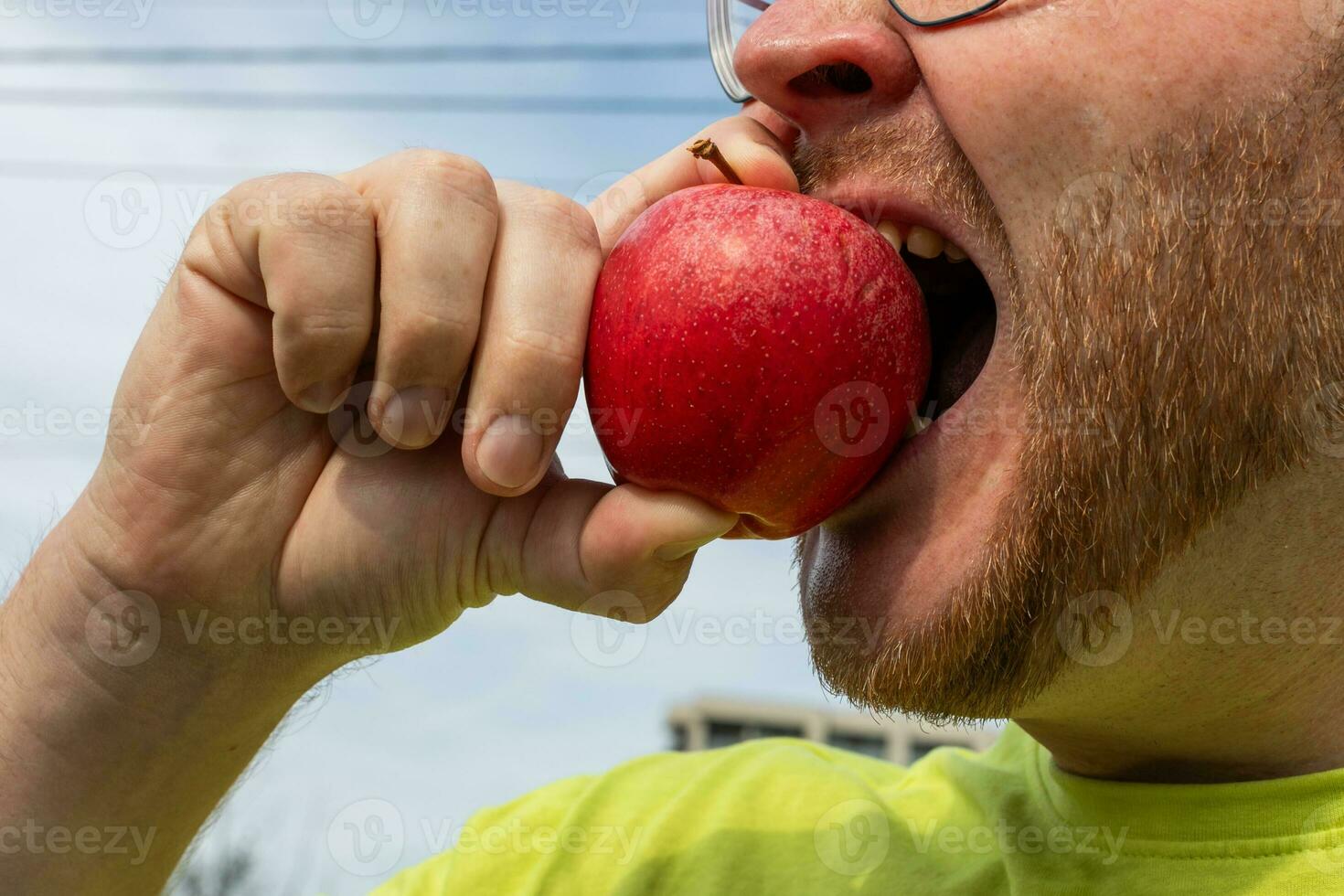 ai generato barbuto uomo gode fresco Mela all'aperto foto