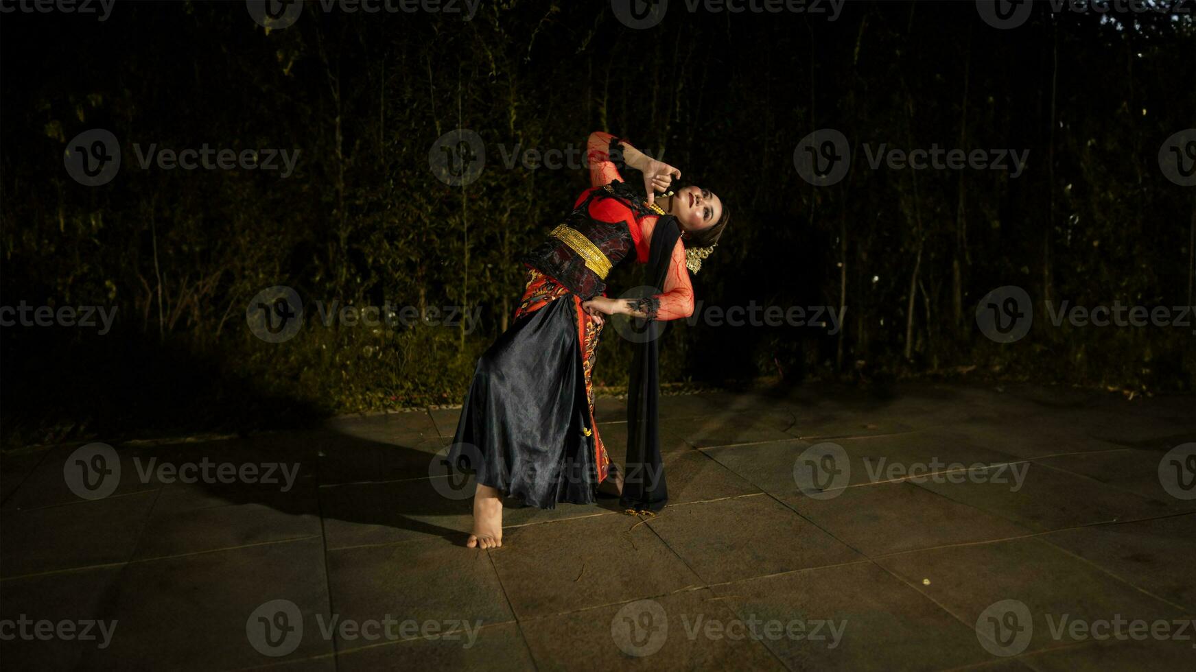 un' giavanese ballerino nel un' rosso costume presentata un' danza quello affascinato il pubblico con il suo abilità foto