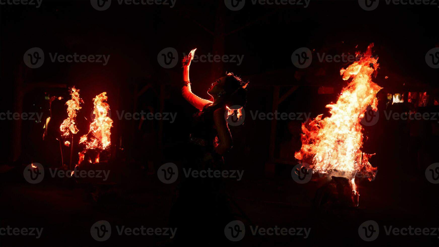 il silhouette di un' femmina ballerino Tenere gioielleria nel il buio di notte è illuminato di il leggero di un' ardente fuoco foto