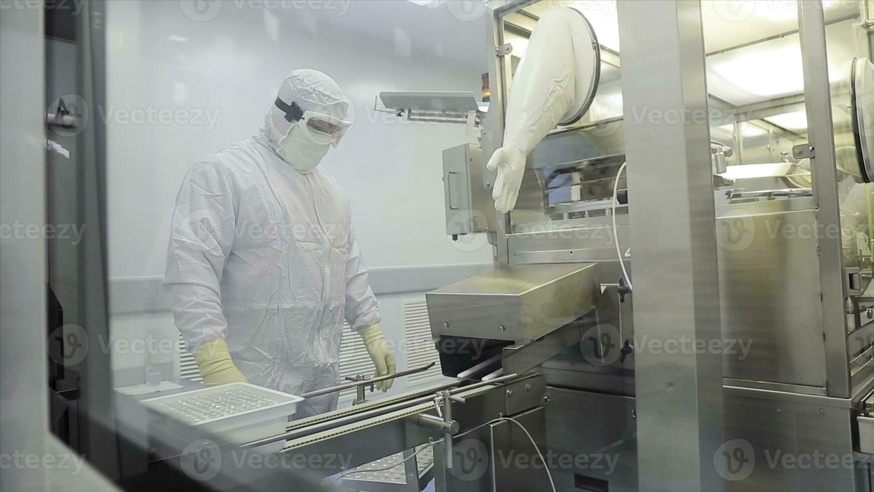 lavoratore nel grembiule, berretto, guanti con tavoletta controllo processi a produzione linea nel fabbrica. qualità controllo lavoratori l'esame pillole nel laboratorio. farmaceutico laboratorio tecnici ispezionando il qualità di foto