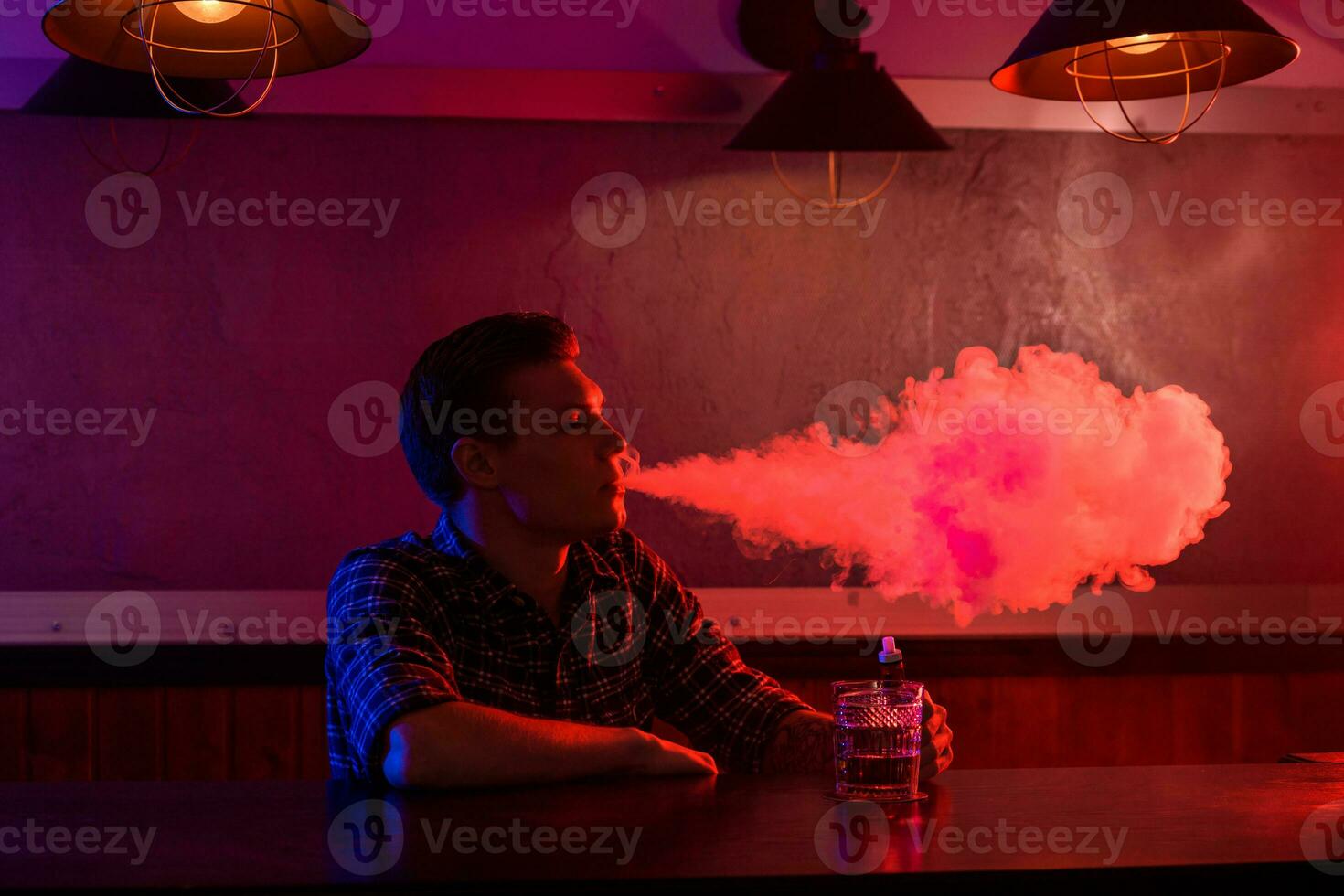 il uomo Fumo un elettronico sigaretta a il Vape negozio. foto