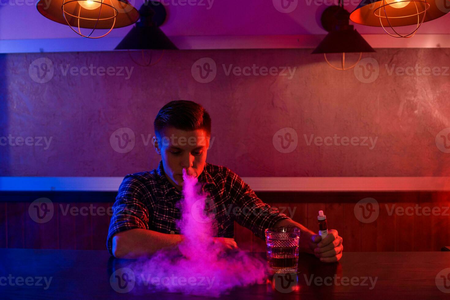 il uomo Fumo un elettronico sigaretta a il Vape negozio. foto