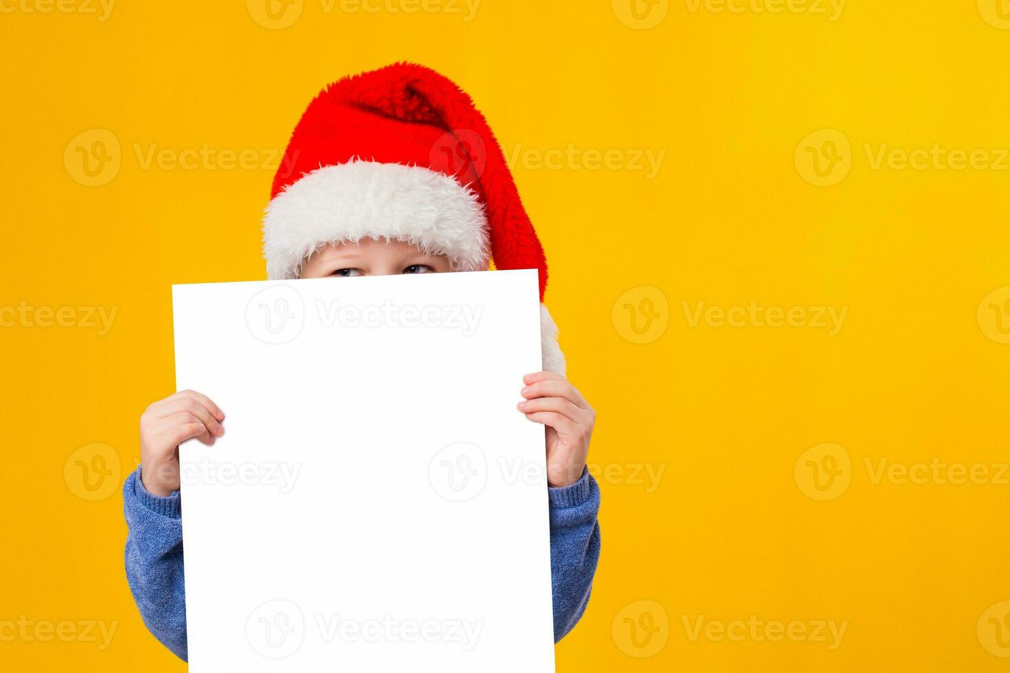 carino poco ragazza nel Santa Claus cappello con un' bianca vuoto carta foglio. Natale, natale, nuovo anno, inverno, le persone, annuncio, vendita concetto. foto