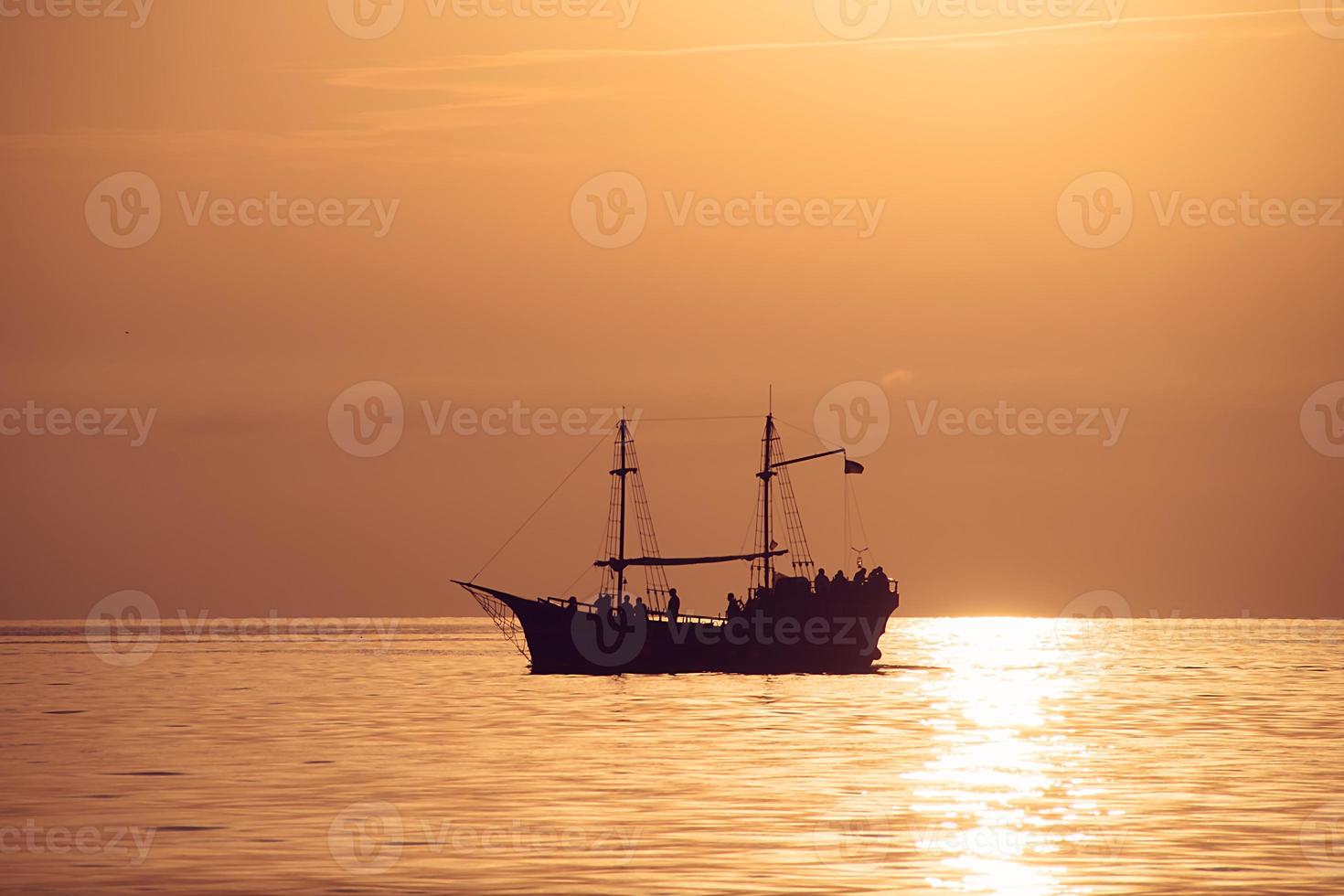 la sagoma di una vecchia nave con alberi contro il tramonto foto