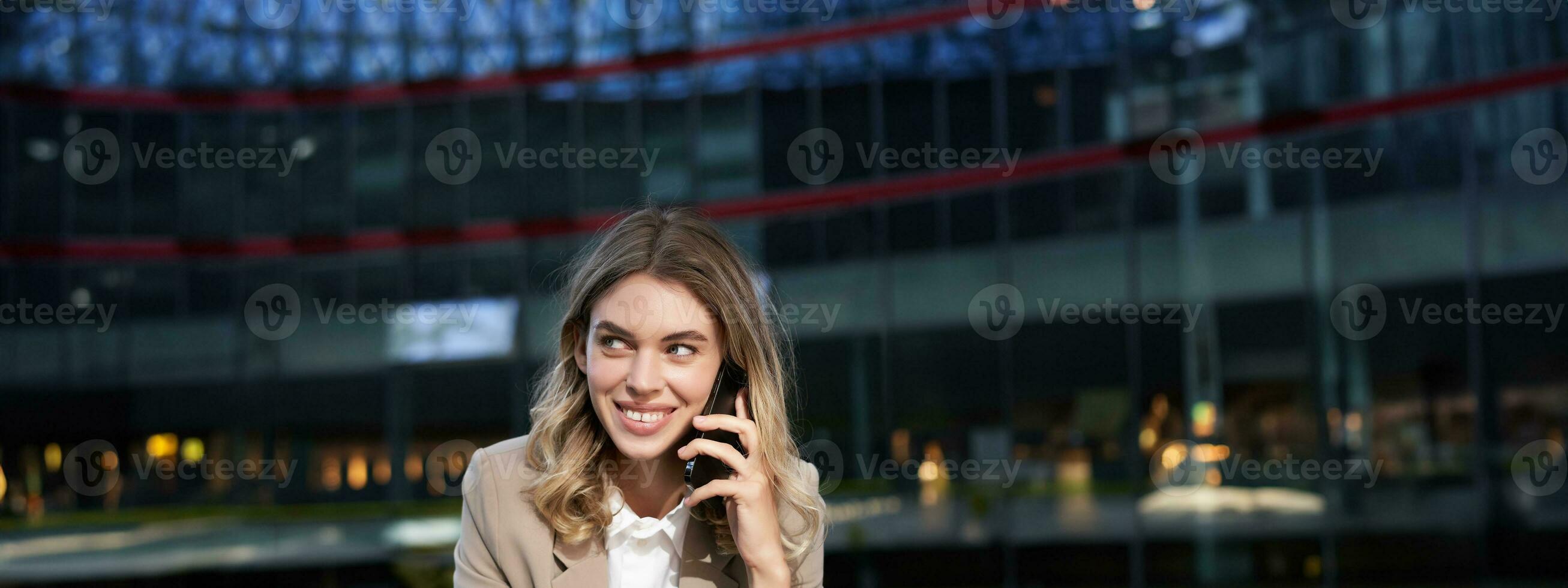 verticale tiro di sorridente donna d'affari risposta mobile Telefono chiamata, parlando su smartphone e potabile caffè foto