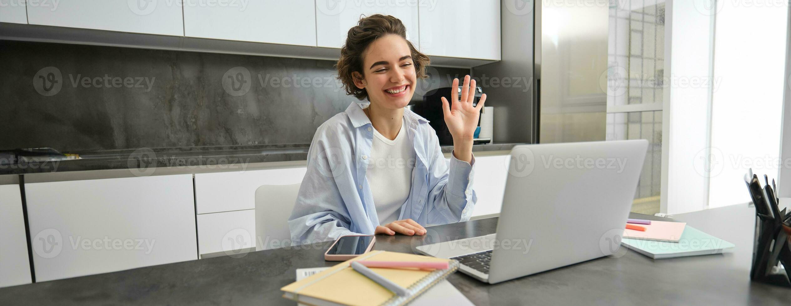 contento giovane donna, precettore insegnante studenti in linea. ragazza si connette per a distanza opera incontro a partire dal sua casa computer portatile, dice ciao, onde mano a computer foto