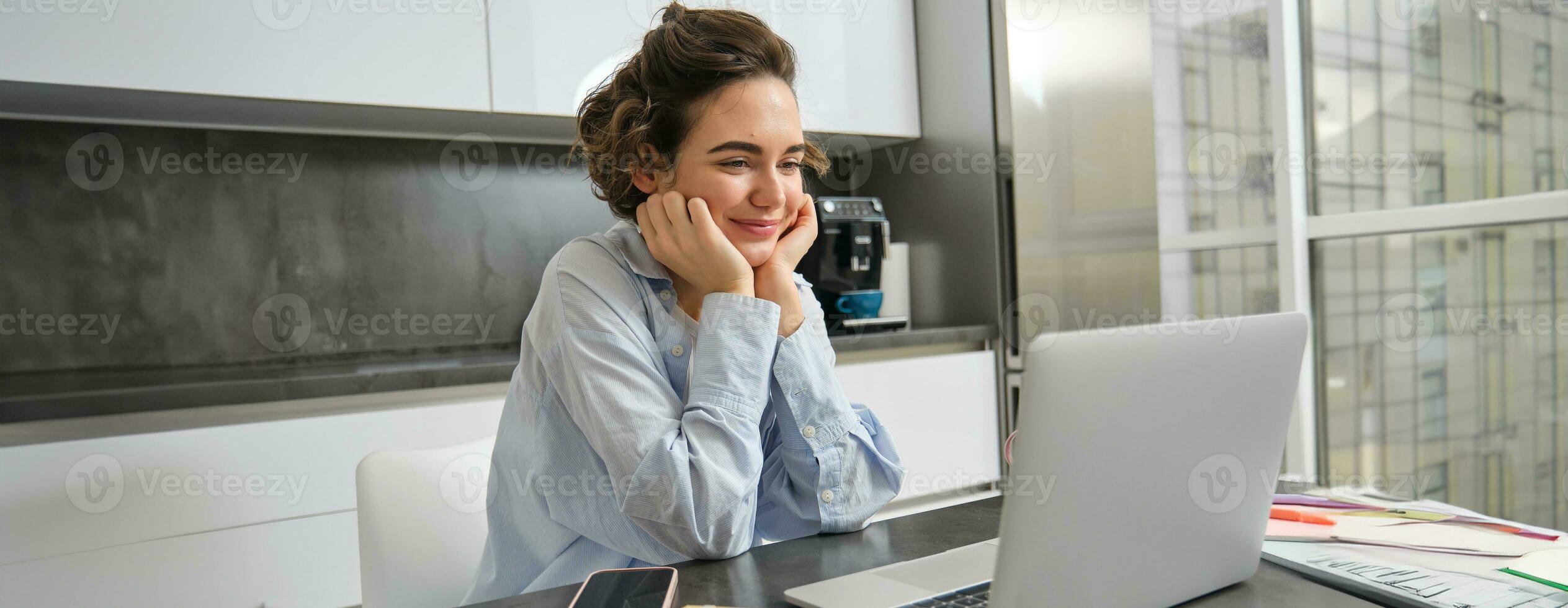 Immagine di sorridente donna studiando su a distanza, guardare a il computer portatile mentre seduta a casa, Guardando seminario web, fare in linea corso su computer foto