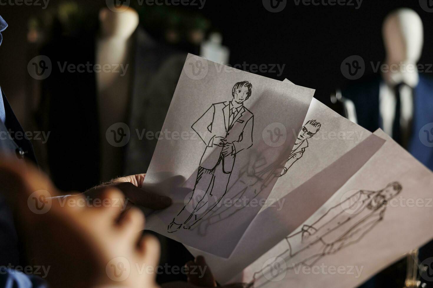 estremo vicino su di schizzo disegni nel sartoria studio mostrando freddo elegante vestiario. qualificato couturier In arrivo su con idee per imminente creativo moda design pista di decollo mostrare foto