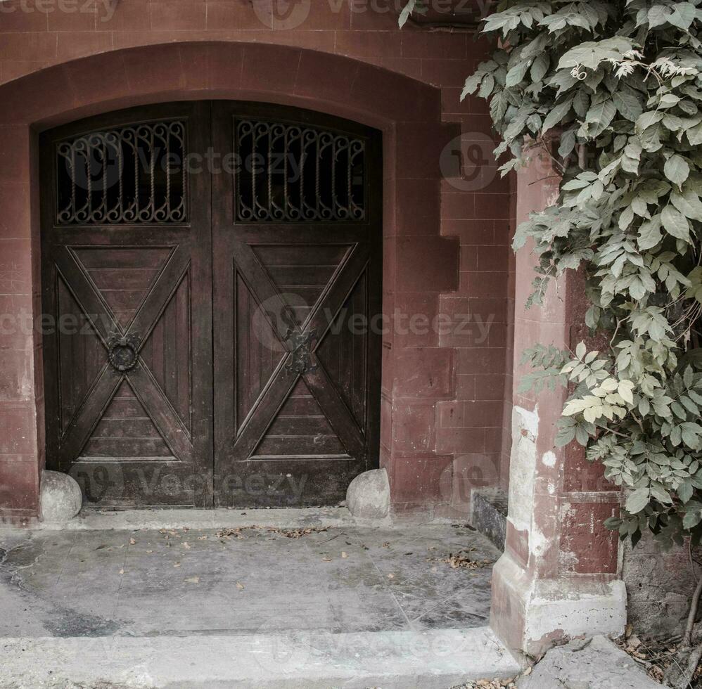 un' medievale chiuso Giardino dietro la casa porta nel un' pietra parete. tipico architettura di Europa. ornato medievale portone nel Barcellona foto