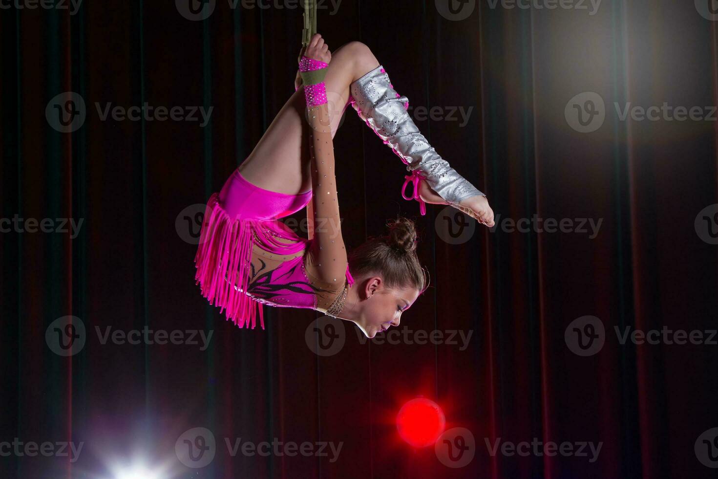 circo artista acrobata prestazione. il ragazza esegue acrobatico elementi nel il aria. circo ginnasta su il palcoscenico foto