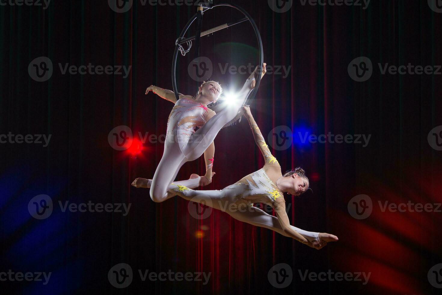 circo attrice acrobata prestazione. Due ragazze eseguire acrobatico elementi nel il aria squillo. foto