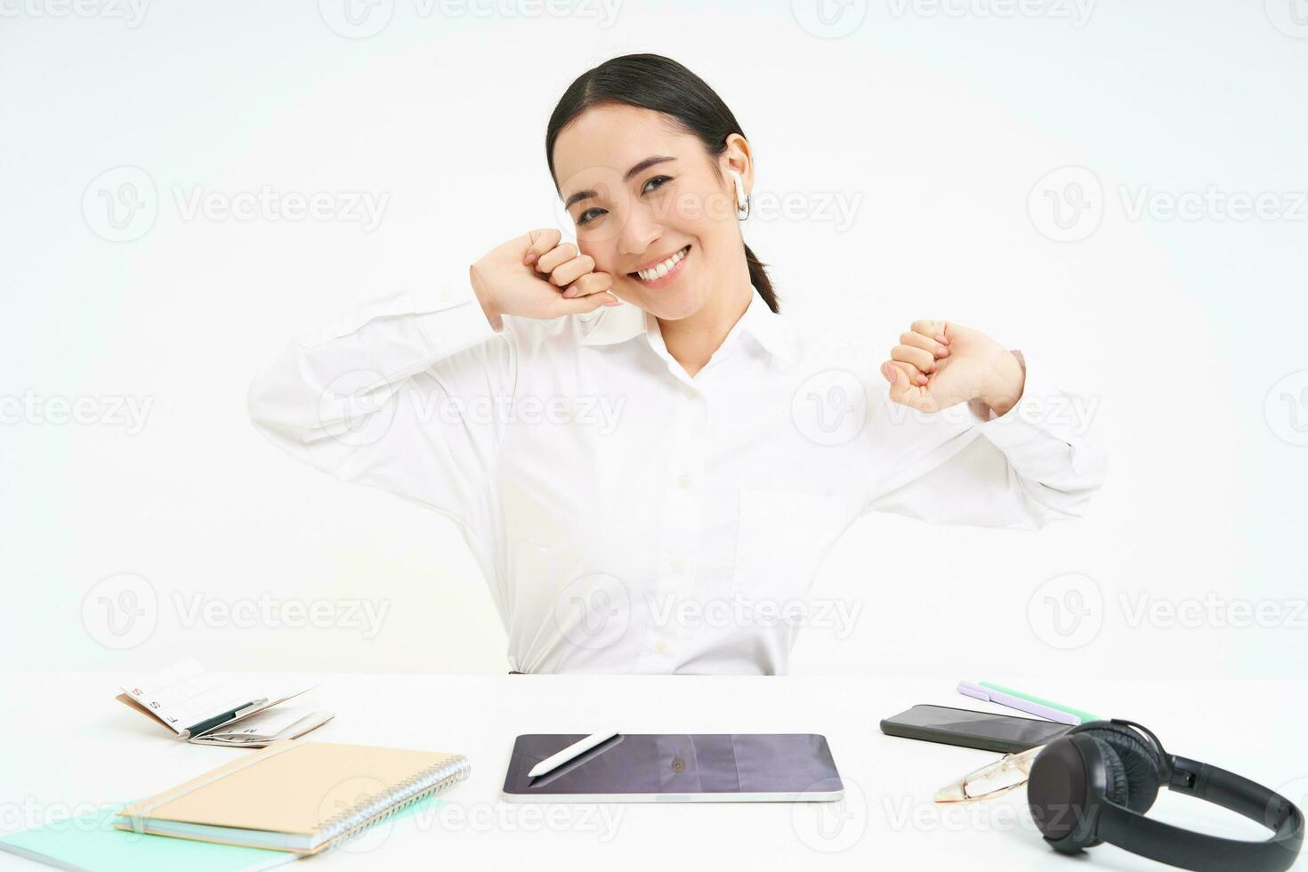 posto di lavoro e attività commerciale concetto. sorridente bellissimo asiatico donna, ufficio lavoratore si siede nel ufficio, tratti sua mani con lieta viso dopo completato opera, bianca sfondo foto