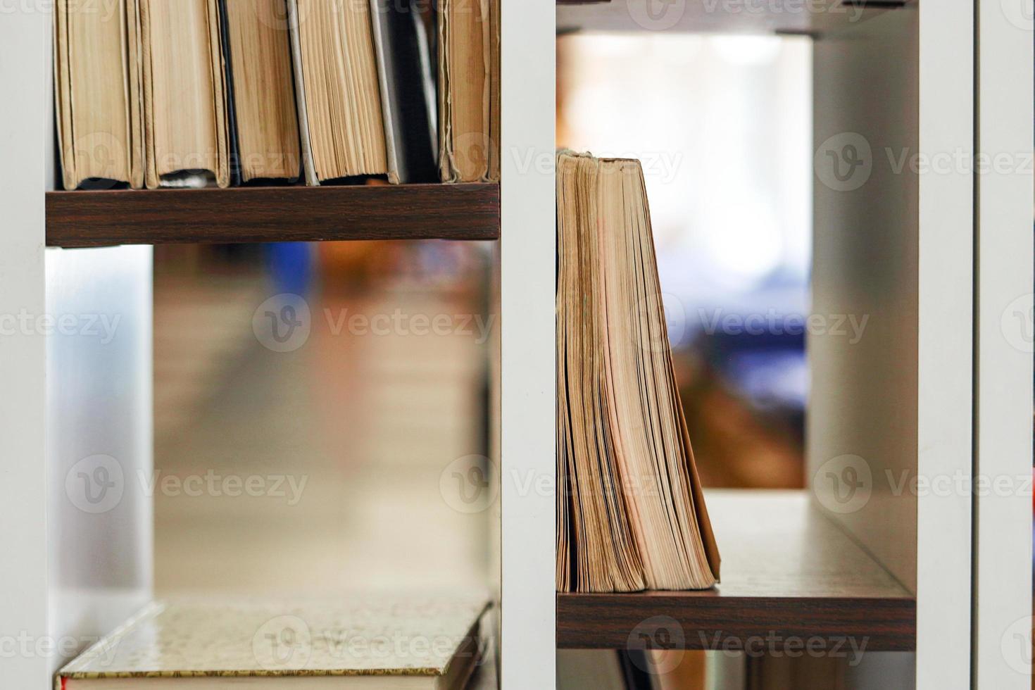 molti libri in piedi e sdraiati sugli scaffali foto